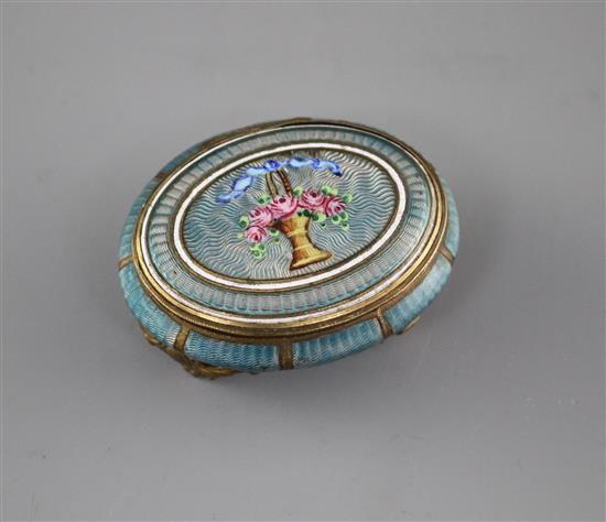 A late 19th century gilt metal and enamel oval box, decorated with a basket of flowers,